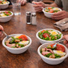 Comida con amigos y ensalada en cuencos de fibra