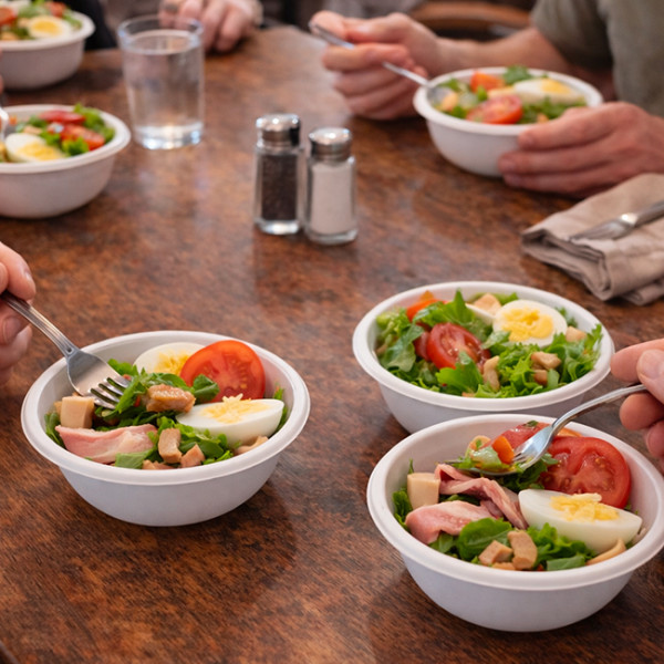 Comida con amigos y ensalada en cuencos de fibra