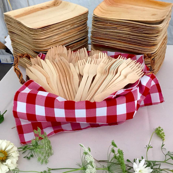Tenedor de madera en cuenco con mantel a cuadros para servicio de comidas al aire libre