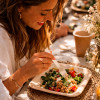 Mujer comiendo ensalada en un plato de bambú con un tenedor de madera