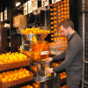 Persona sirviéndose zumo de naranja en un supermercado