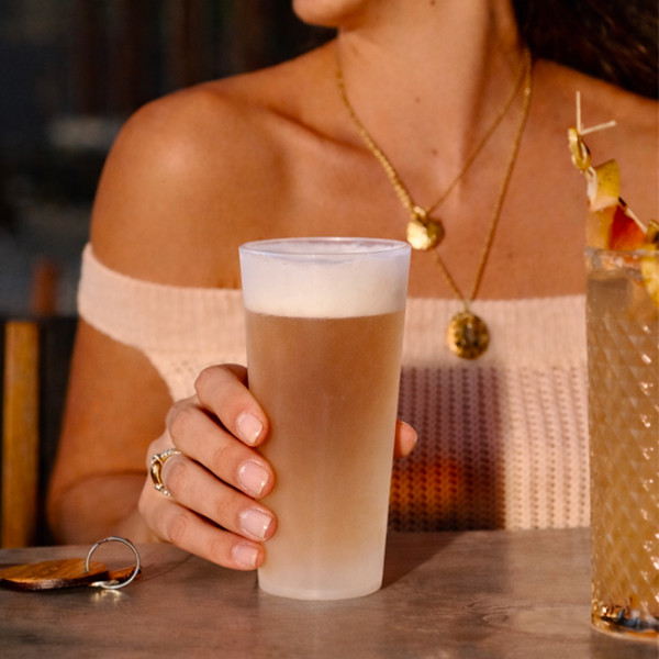 Mujer bebiendo un vaso de plástico translúcido