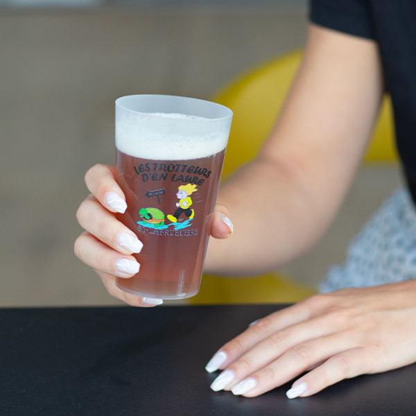 Persona bebiendo de un vaso reutilizable codificado por colores