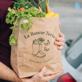Bolsa kraft personalizada rellena de verduras y vendida en un mercado por un verdulero